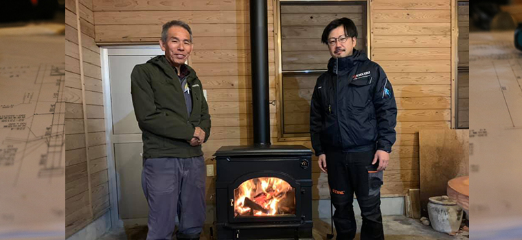 火が入ったエンライトをはさんで並ぶ田中さんと、施工を担当した田淵金物の田淵さん